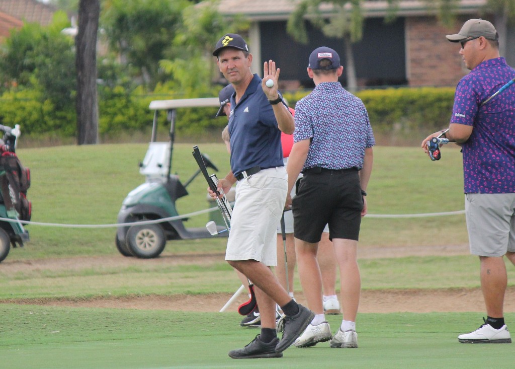 Member holding up a golf ball on the green