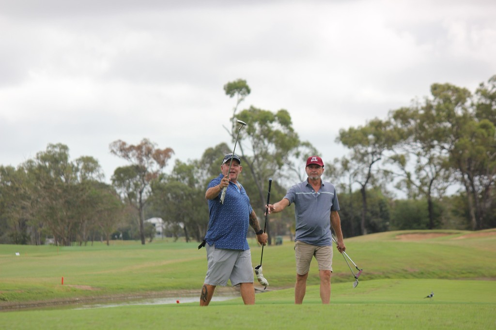 Two mates posing with clubs on the fairway