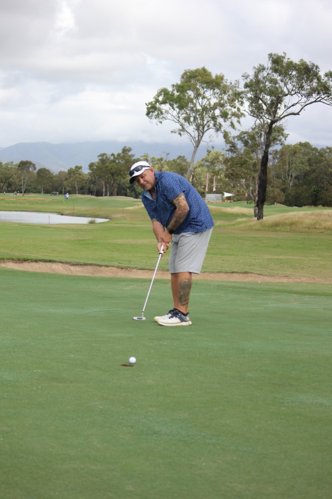 Member putting with mountains in the background